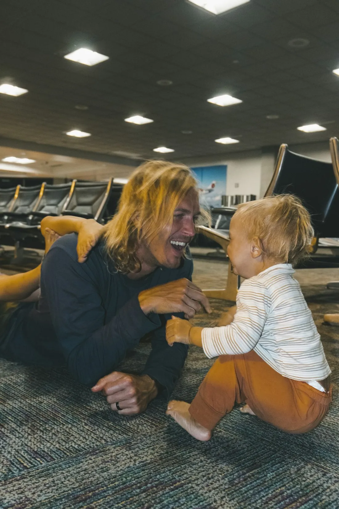 A parent and laughing toddler enjoying the airport
